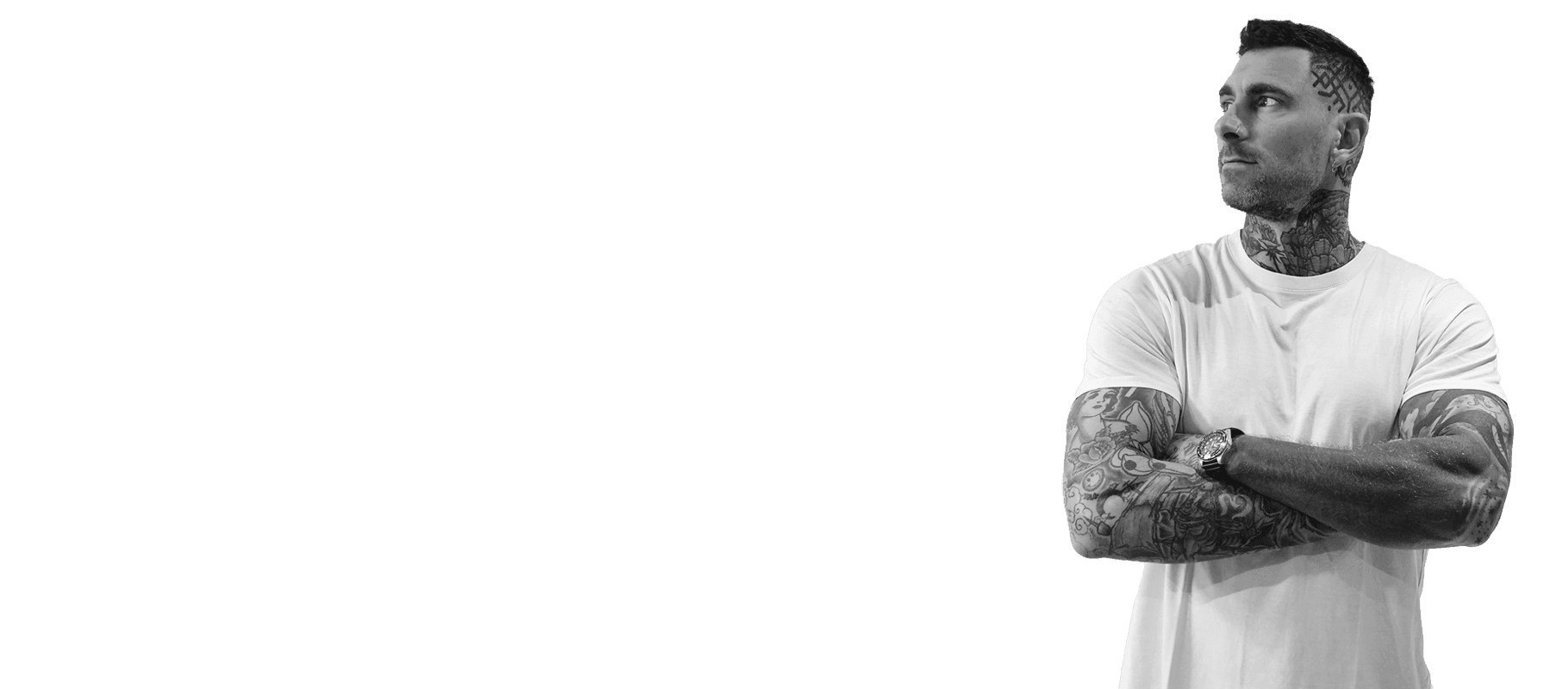 Tattooed man with arms crossed, looking away from the camera